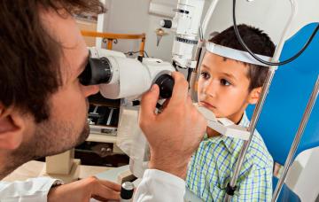 Un oftalmólogo revisa la vista a un niño
