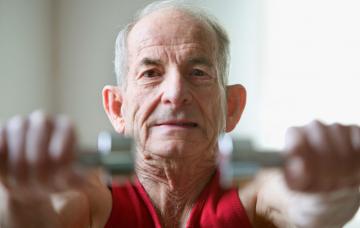 Anciano haciendo ejercicio con pesas