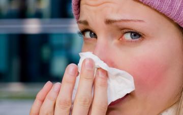 Mujer sonándose la nariz