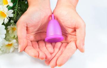 Manos de mujer sosteniendo una copa menstrual