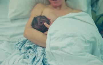 Mujer dando el pecho estando enferma en la cama