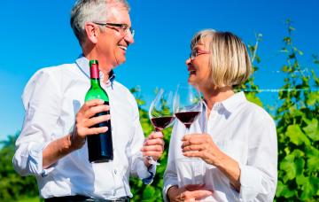 Pareja mayor tomando vino tinto