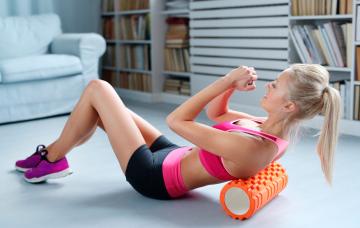 Chica entrenándose con un foam roller