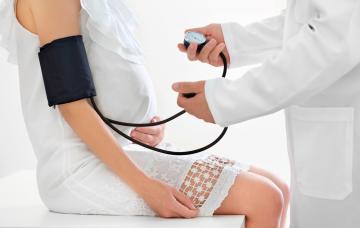 Hipertensión gestacional Doctor tomando la tensión a una embarazada