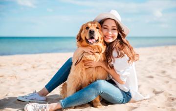 A la playa con tu perro Mujer en la playa con su perro