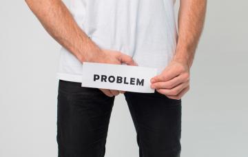 Qué es el priapismo Un hombre se toca el pene por encima de la ropa