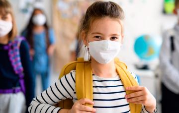 Vuelta al cole segura Niña en el colegio con la mascarilla puesta