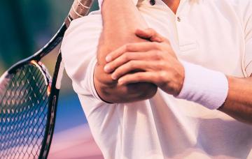 Tenista doliéndose del codo por epicondilitis