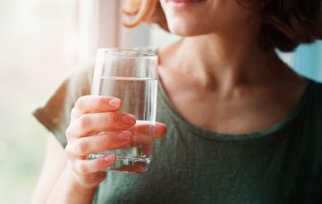 Mujer bebiendo agua por la mañana