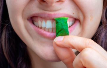 Qué es el snus o bolsas de nicotina Mujer joven consumiendo una bolsa de snus