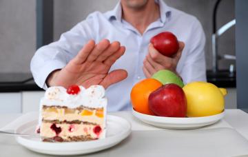 Hombre cambiando el dulce por fruta