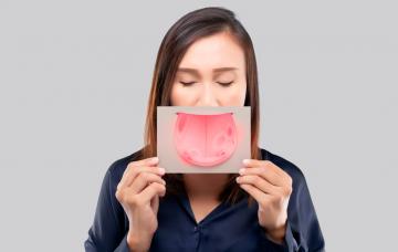 Mujer sosteniendo una hoja impresa con una lengua infectada por úlceras