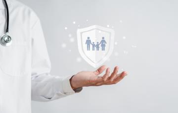 Doctor mostrando un icono de una familia protegida por seguro médico