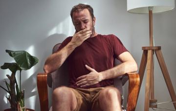 Hombres se tapa la boca al eructar con mal olor