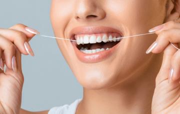 Chica usando un hilo dental después de comer