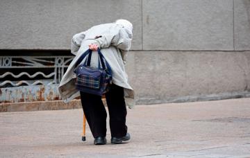 Curvatura de la espalda debido a la edad Mujer de avanzada edad camina con una marcada curvatura de la espalda