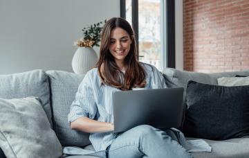 Test ¿Eres una persona disciplinada? Mujer trabajando con su portátil en en salón de su casa