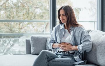 ¿Cómo se relacionan el peso y la menstruación? Mujer joven con dolor por la regla