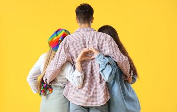 Un chico abrazado a dos chicas