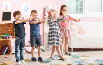 Juegos para desarrollar la inhibición conductual Niños pequeños en clase jugando al juego de la estatua
