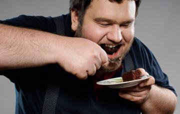 Hombre con food craving devora un postre