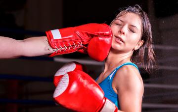 Mujer siendo golpeada en la mandíbula tras practicar boxeo