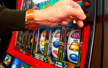 Hombre ludópata jugando en una máquina de casino