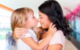 Una mujer abraza a su hija, que la besa en la nariz