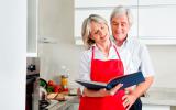 Una pareja madura consulta un libro de cocina