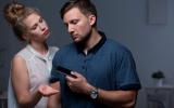 Mujer reclamándole el móvil a su pareja como concepto de gaslighting o manipulación