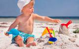 Niño jugando con la arena de playa