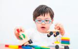 Un niño con síndrome de Down juega con unos juguetes