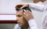 El dermatólogo explora el cuero cabelludo de un paciente