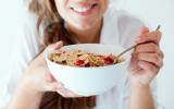 Mujer tomando cereales, alimentos recomendados en el reflujo gastroesofágico
