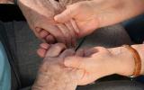 Agarrando las manos de paciente con síntomas del alzhéimer