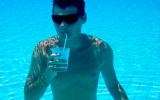 Hombre bebiendo en pajita debajo del agua