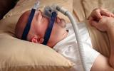 Varón con una mascarilla CPAP para la apnea del sueño
