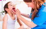 Niño en el pediatra para tratar las inflamación de las amígdalas
