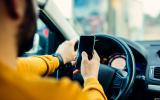 Padres millennials conduciendo y distraido por el móvil