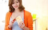 Mujer embarazada tomando alimentos con conservantes