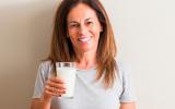 Mujer tomando leche desnatada para disminuir el riesgo de cáncer de colon