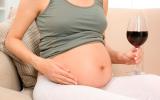 Mujer embarazada bebiendo una copa de vino