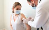 Enfermero vacuna de COVID-19 a una mujer adulta en España