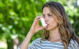 Mujer asmática usando su inhalador