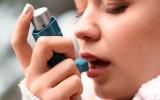 Mujer joven inhalando un corticoide para el asma