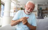 Hombre mayor con osteoartritis en las manos