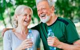 Una pareja mayor haciendo ejercicio y bebiendo agua
