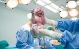 Médico sujetando a un recién nacido