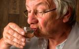Un hombre mayor bebiendo alcohol