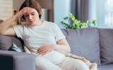 Embarazada con síntomas de ansiedad sentada en el sofá